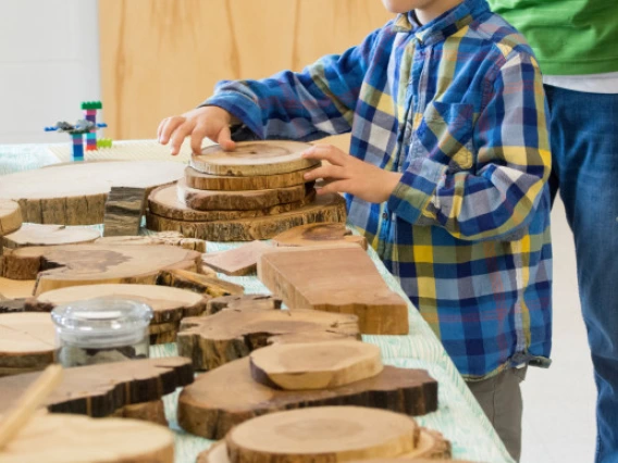 Child at table of wood samples