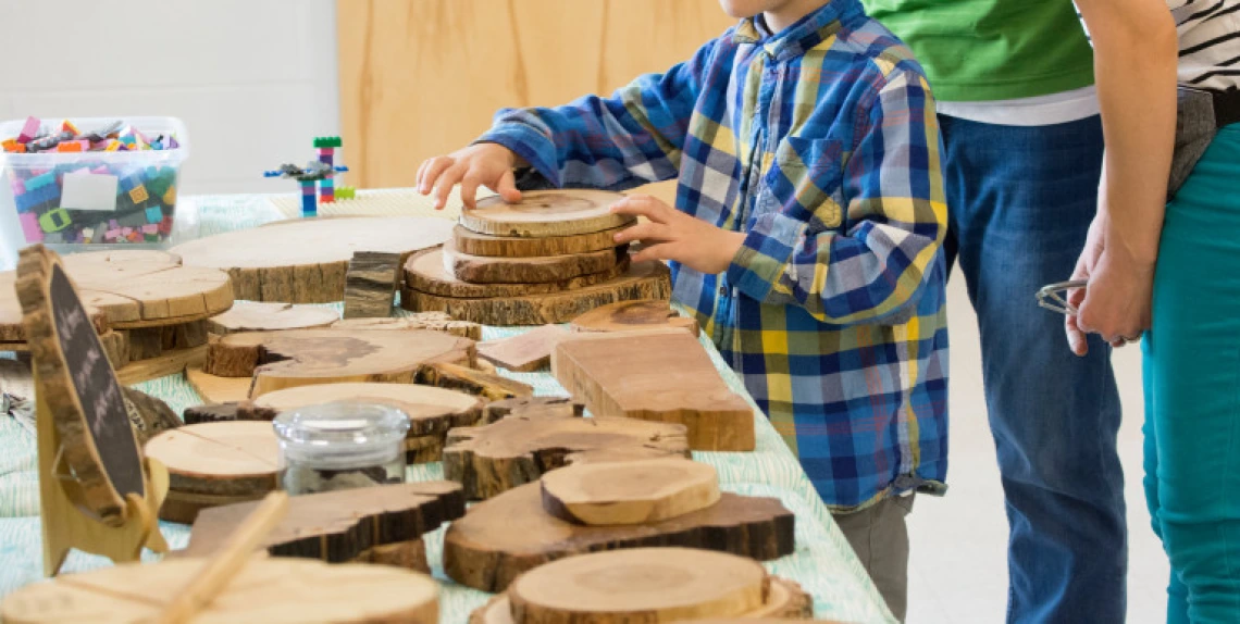 Child at table of wood samples