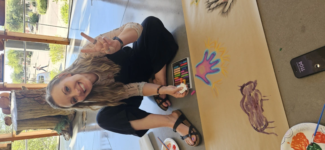 TUSD Art teacher Lena Alelunas creating cave-style art using chalk pastels.